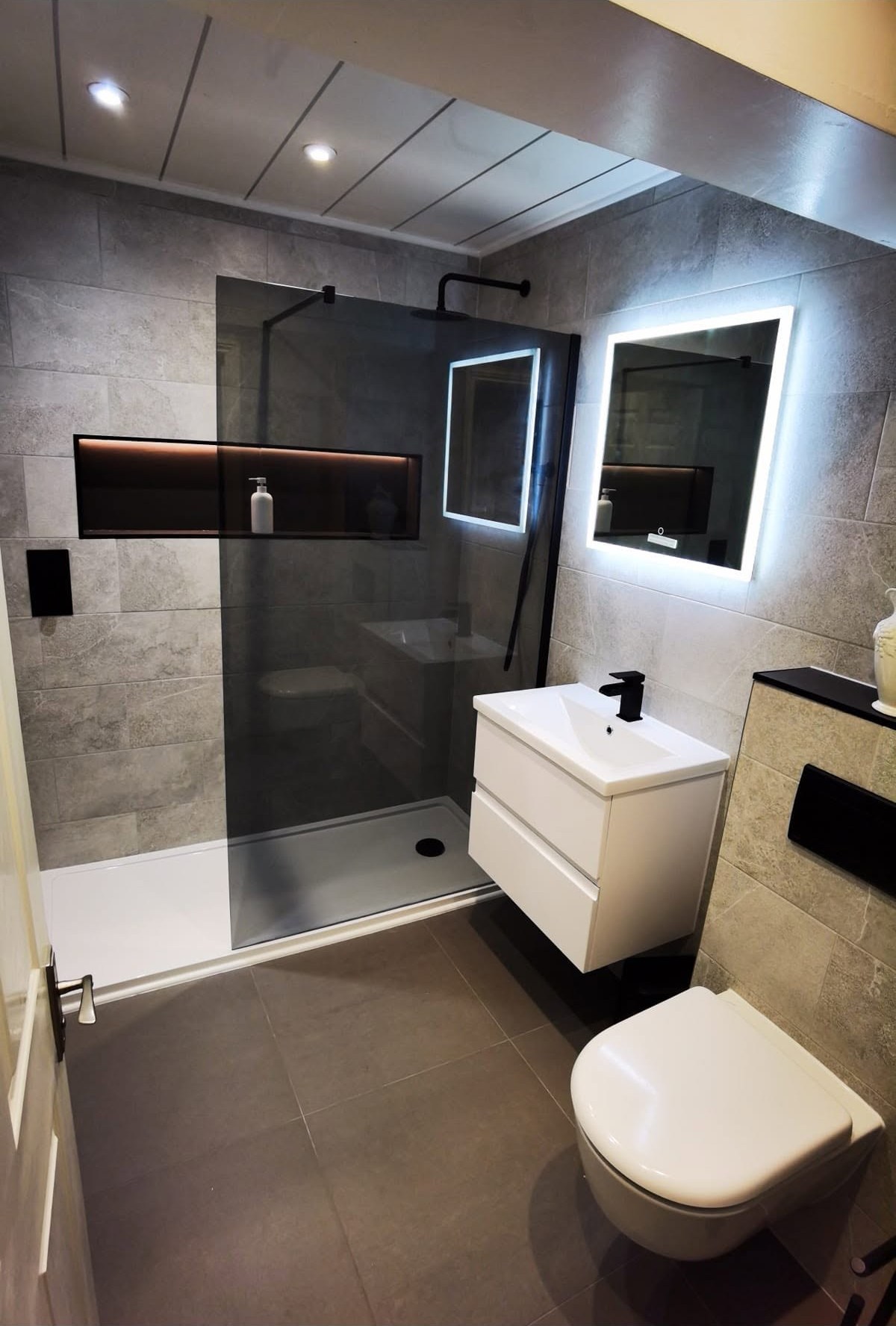 Walk-in shower room with a lit niche and wall hung units, Ashburys Property Renovations, Stockport