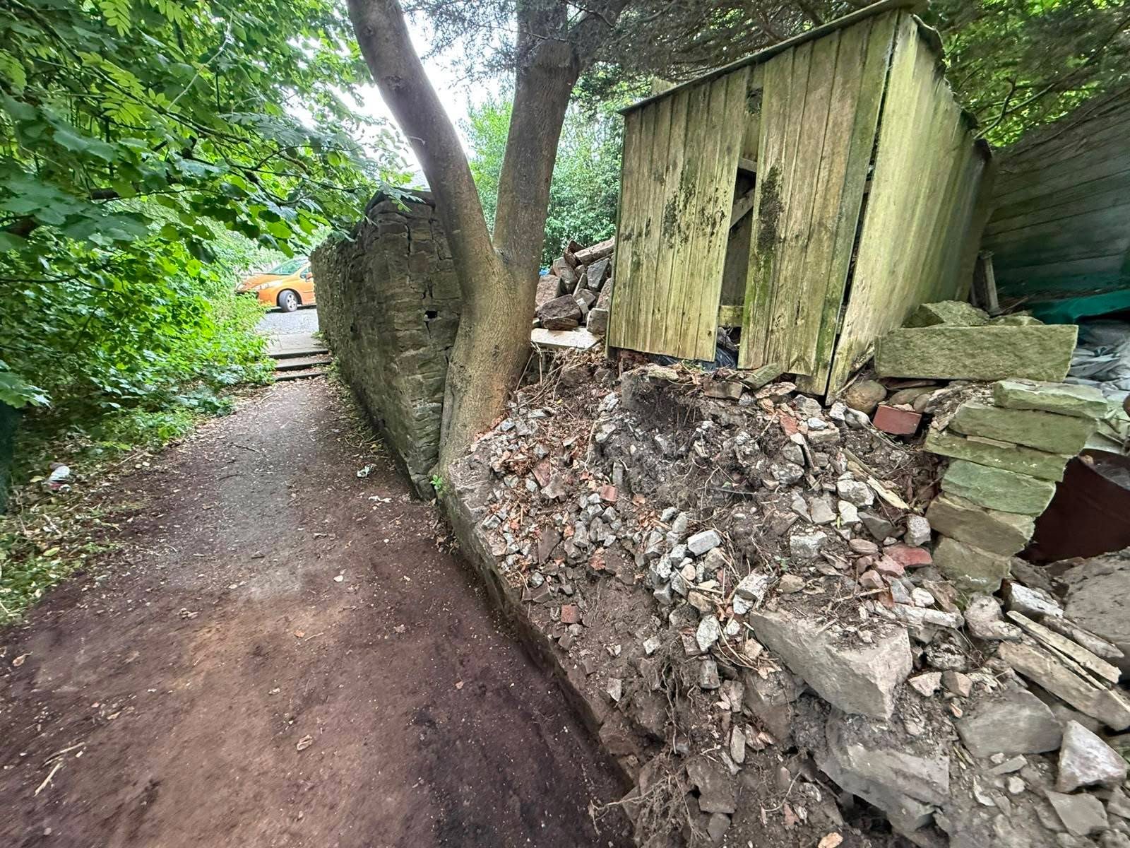 Before: the collapsed wall and shed beside the path
