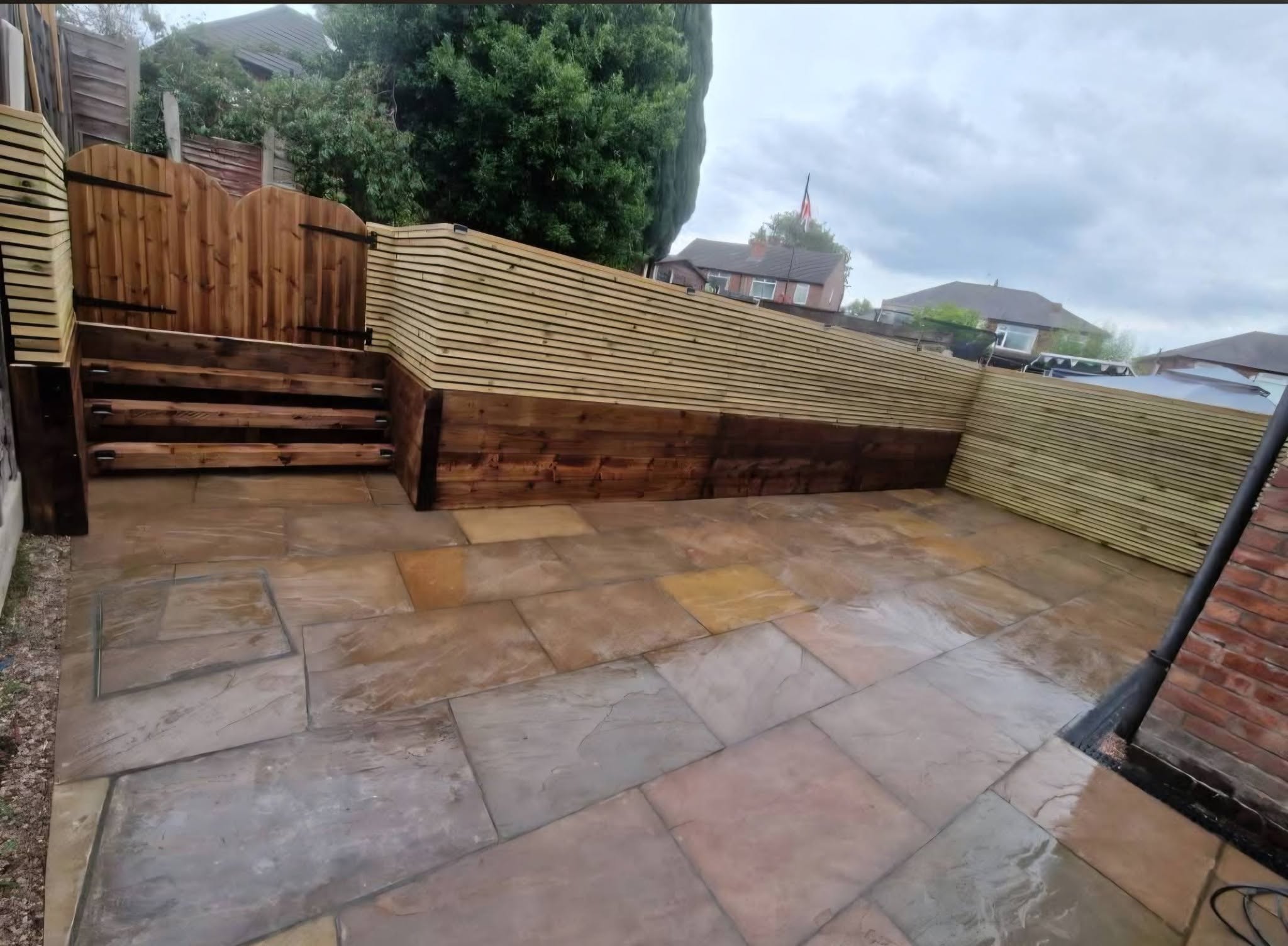 Indian stone patio with sleeper retaining wall and new fencing